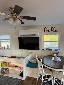 a living room with a table and a ceiling fan at Dragonfly Cottage in Plymouth
