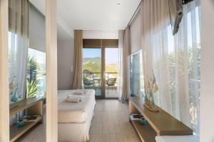 a bedroom with a bed and a large window at Christie's Luxury Suites by Dandy Hospitality in Syvota