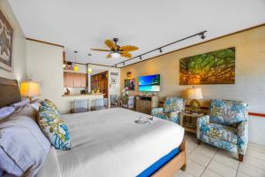 a bedroom with a large bed and two chairs at Lahaina Shores 631 in Lahaina