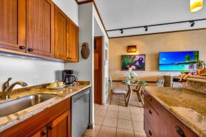 a kitchen with a sink and a dining room at Lahaina Shores 631 in Lahaina