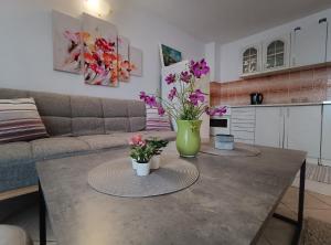 a living room with a table with flowers on it at Apartments Vuleta in Pag