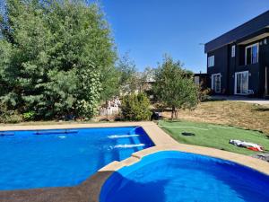a swimming pool in front of a house at Hostal Tour Ñuble in General Bernardo O'Higgins