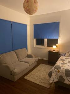a living room with a couch and a bed and a window at Hostal Tour Ñuble in General Bernardo O'Higgins