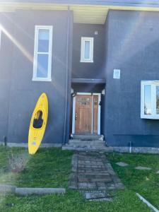 a yellow kayak sitting outside of a house at Hostal Tour Ñuble in General Bernardo O'Higgins