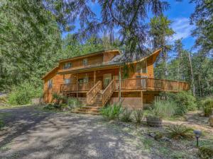 a log home with a large deck and stairs at Salmon River Chalet - Meredith Lodging in Welches