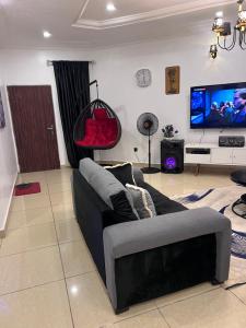 a living room with a couch and a flat screen tv at New Luxury in Gwarinpa