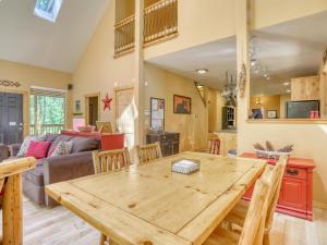 a kitchen and living room with a wooden table at Salmon River Chalet - Meredith Lodging in Welches