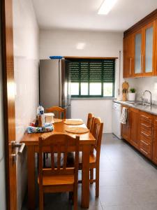 a kitchen with a wooden table and some chairs at Entre Ilhas in Horta