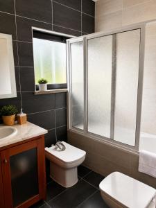 a bathroom with a toilet and a sink and a shower at Entre Ilhas in Horta