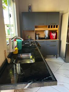 a kitchen with a sink and a counter top at Casa do kell in Itaúnas