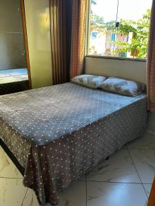 a bed in a room with a window at Casa do kell in Itaúnas