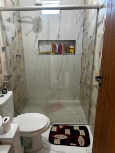 a bathroom with a shower with a toilet and a rug at Casa do kell in Itaúnas +20 photos