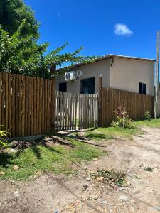 a wooden fence in front of a house at Casa do kell in Itaúnas