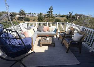a porch with a hammock and chairs and a swing at Casa Pacifica in San Pedro