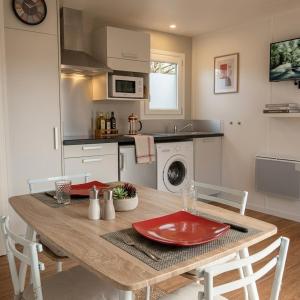 a kitchen with a wooden table with red plates on it at Les Logis de la Seugne in Saint-Germain-de-Lusignan +15 photos