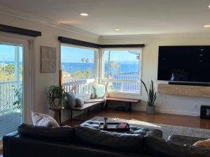 a living room with a leather couch and large windows at Casa Pacifica in San Pedro +34 photos