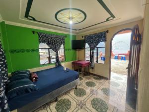 ein Schlafzimmer mit einem blauen Bett und grünen Wänden in der Unterkunft Hotel Henderson in San Pedro La Laguna