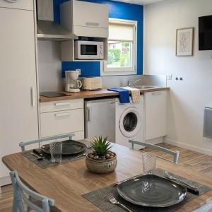 a kitchen with a table and a washing machine at Les Logis de la Seugne in Saint-Germain-de-Lusignan