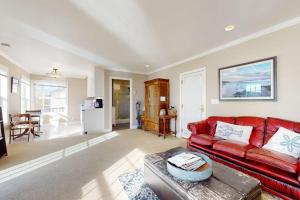 a living room with a red couch and a table at Bayside Cottage in Bodega Bay