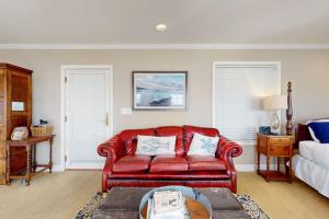 a living room with a red couch and a bed at Bayside Cottage in Bodega Bay