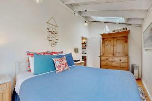 a bedroom with a blue bed and a wooden cabinet at Mar-Tiny in Bodega Bay