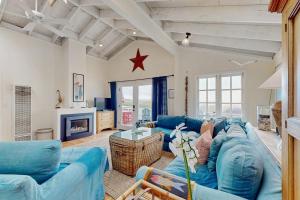 a living room with blue couches and a star on the wall at Mar-Tiny in Bodega Bay