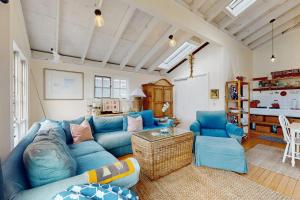 a living room with a blue couch and chairs at Mar-Tiny in Bodega Bay +9 photos