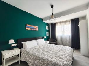 a bedroom with a bed and a green wall at 51 E-scape Home in Corralejo +47 photos
