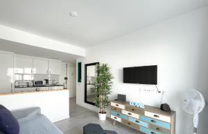 a living room with a couch and a tv on a wall at 51 E-scape Home in Corralejo