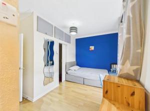 a room with a bed and a blue wall at Lake District Gate in Lancaster