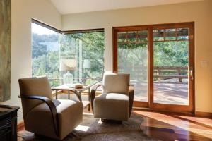 a living room with two chairs and a table and sliding glass doors at Leslie Creek House in Mark West Springs +46 photos