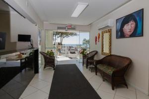 a living room with chairs and a table and a painting at Pousada Roberto Monteiro - Frente Mar in Florianópolis