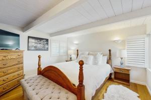 a white bedroom with a bed and a dresser at Sunset Escape in Bodega Bay