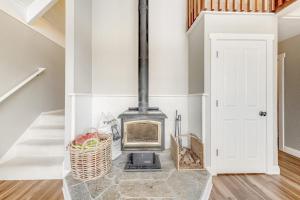 a fireplace in a white room with a staircase at Whaleship Harbor View in Bodega Bay