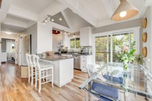 a kitchen with white cabinets and a glass table at Whaleship Harbor View in Bodega Bay