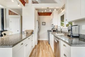a kitchen with white cabinets and granite counter tops at Whaleship Harbor View in Bodega Bay
