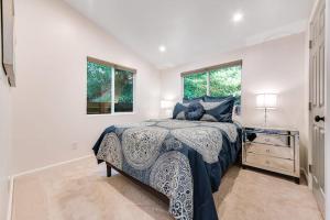 a white bedroom with a bed and a window at Canyon House in Guerneville