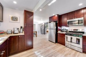 a large kitchen with wooden cabinets and stainless steel appliances at Canyon House in Guerneville +13 photos