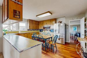 a kitchen with a table and chairs and a refrigerator at Cozy Carmet Cottage in Bodega Bay