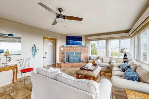 a living room with white couches and a fireplace at Cozy Carmet Cottage in Bodega Bay