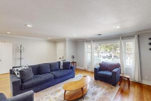 a living room with a blue couch and two chairs at James House in Santa Rosa