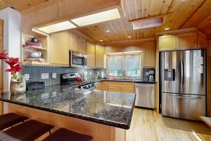 a kitchen with wooden cabinets and a stainless steel refrigerator at Monte Rio Dream in Monte Rio