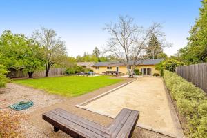 a backyard with a bench and a house at Kenwood Retreat in Kenwood