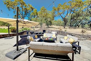 a patio with a couch and an umbrella at Warm Springs Paradise in Glen Ellen
