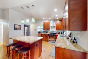 a kitchen with wooden cabinets and a island with bar stools at River Paradise in Guerneville