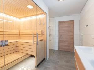 a bathroom with a sauna with a tub and a sink at Villa Petra in Donnersbachwald +24 photos