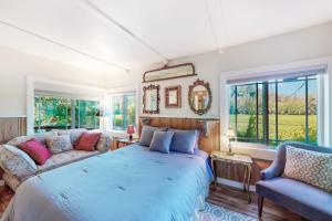 a bedroom with a bed and a couch and windows at Vineyard Cottage in Guerneville