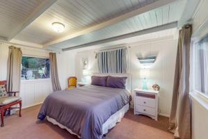 a bedroom with a bed and a chair and a window at Seaside Cottage in Bodega Bay