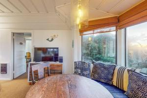 a living room with a table and a large window at Seaside Cottage in Bodega Bay