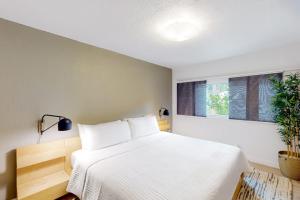 a bedroom with a white bed and a window at Riverfront Escape in Monte Rio